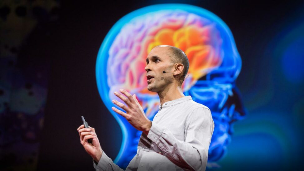 man standing in front of a colour inside image of a human head